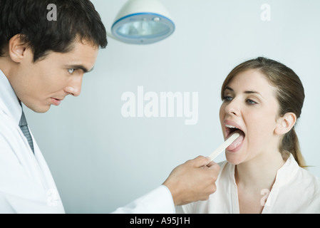 Arzt Frau Zunge mit Zunge Depressor gedrückter Stockfoto