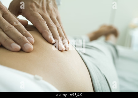 Die Hände des Mannes auf schwangere Frau Bauch Stockfoto