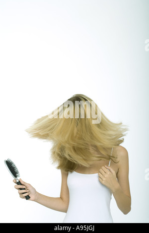 Teenager-Mädchen hält Pinsel schwingen Haare Stockfoto