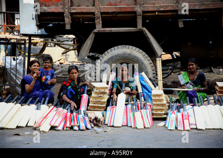 Indische Frauen verkaufen Cricket Fledermäuse an der Seite der Straße, Vadodara, Gujarat, Indien Stockfoto