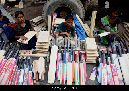 Indische Frauen verkaufen Cricket Fledermäuse an der Seite der Straße, Vadodara, Gujarat, Indien Stockfoto