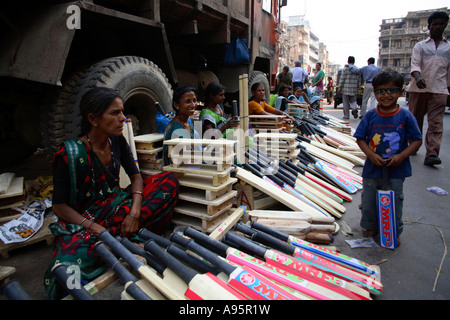 Indische Frauen verkaufen Cricket Fledermäuse an der Seite der Straße, Vadodara, Gujarat, Indien Stockfoto