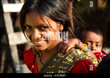 Indische Frau, die Kind auf dem Rücken außerhalb des Shanty Home, D'Mello Road, Mumbai, Indien Stockfoto