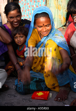 Fröhliche indische Frauen spielen Karten auf der Straße vor Slum Haus, D'Mello Road, Mumbai, Indien Stockfoto