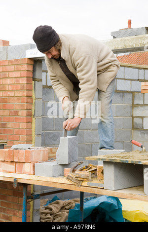 Maurer mit Stemmeisen Kropf, ^ schneiden Bausteine Stockfoto