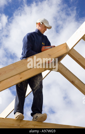 Baumeister Hausbau ein neues Dach für eine Erweiterung zu einem Haus mit einem Bolzenschußgerät Stockfoto