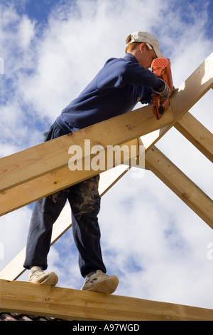 Baumeister Hausbau ein neues Dach für eine Erweiterung zu einem Haus mit einem Bolzenschußgerät Stockfoto