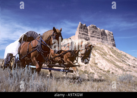 WAGENZUG WEITERGIBT "OREGON TRAIL-WAGEN-ZUG" IN DER NÄHE VON BAYARD, NEBRASKA SANDSTEIN-KLIPPEN. Stockfoto