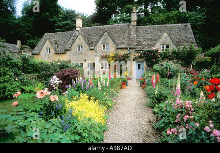 Alten Hütten und traditionellen englischen Cottage-Gärten mit Blumen im Sommer Bibury Dorf Gloucestershire Cotswolds Stockfoto