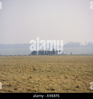 Atmosphärische Fernblick von Stonehenge im nebligen Dunst am frühen Morgen mit Schafherde Wandern auf Salisbury Plain England Stockfoto