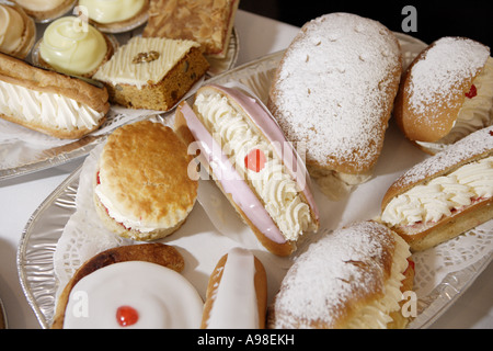 Naschkatzen, die frisch gebackenen Scones frische Sahne Brötchen und Kuchen in der Bäckerei bereit zu verkaufen Stockfoto