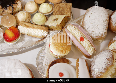 Naschkatzen, die frisch gebackenen Scones frische Sahne Brötchen und Kuchen in der Bäckerei bereit zu verkaufen Stockfoto