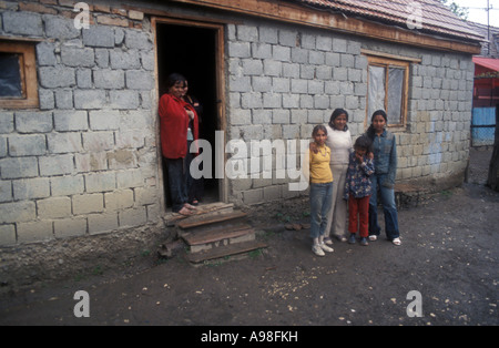 Gruppe von Menschen Stellung außerhalb Zement Blockhaus im Abschnitt "Gypsy" von der der rumänischen Dorf Soard. Stockfoto