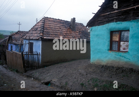 Drei ein Zimmer bunt bemalten Häuser säumen die Straße von der rumänischen Dorf Soard.  Das Haus sitzen auf Schlamm. Stockfoto