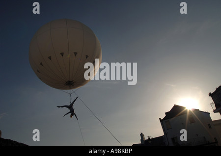 Eine riesige Helium-Ballon mit einer Antenne Trapezkünstler unter driftete über Zuschauer auf Dorsets Jurassic Coast Arts ausgesetzt Stockfoto