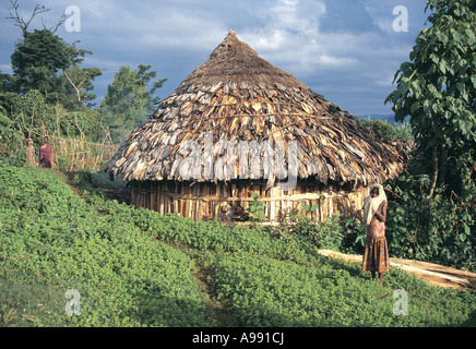Junge Frau, die außerhalb ihrer traditionellen Behausung Tulkul Äthiopien Sidamo region Stockfoto