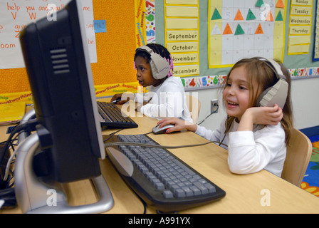 Schülerinnen und Schüler nutzen Computer mit Kopfhörer, Sprache in ihrem Klassenzimmer zu lernen Stockfoto