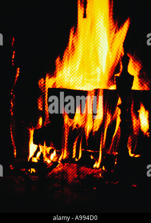 Nahaufnahme von einem prasselnden Feuer im Kamin durch einen Kaminschirm, die, den Flammen aus einem Haufen von gestapelte Holz aufsteigen Stockfoto