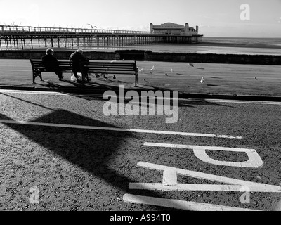 Altes Ehepaar auf einer Bank am Strand von Weston-Super-Mare, Somerset, England. (Schwarz / weiß-Bild) Stockfoto