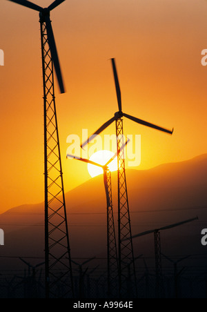 Moderne Silhouette durch die untergehende Sonne hinter den Bergen in der Nähe von Palm Springs Kalifornien Windmühlen zur Stromerzeugung Stockfoto