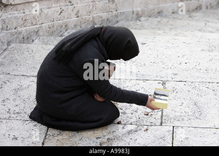 Eine Bettler Frau sitzt auf dem Bürgersteig an der Piazza di Spagna in Rom, Italien Stockfoto