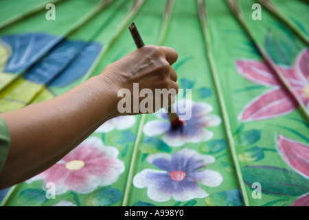 Fabrikarbeiter, Malerei einen Regenschirm im Umbrella Making Centre in Bo Sang Thailand. Stockfoto
