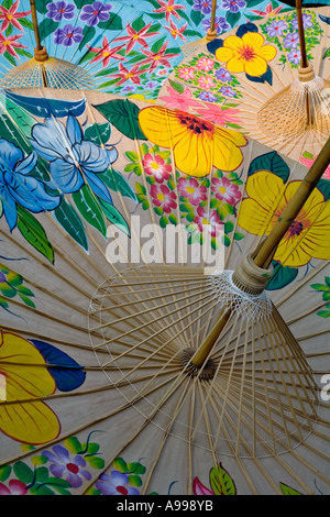 Die Unterseite des handgeschöpfte Baumwolle Schirme mit bunt gemalten Blumen zeigen die Bambus-Rippen am Dach machen Zentrum. Stockfoto