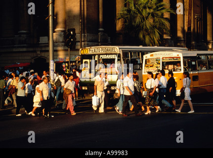 Fußgänger überqueren O Higgins Avenue auch bekannt als die Alameda vor Bussen in der Innenstadt von Santiago Chile Stockfoto