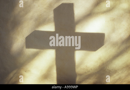 Schatten des Kreuzes werfen auf Creme lackiert rauhe Wand mit Projektion von einfachen Diamant verbleit Glasscheiben Kirchenfenster Stockfoto