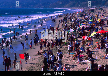 Drängen sich Touristen Sonnenanbeter und Schwimmer den Strand und das Wasser in Santa Monica, Kalifornien Stockfoto
