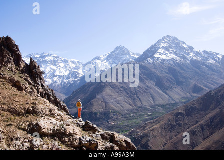 Trekker mit Blick auf das riesige Mizane Tal in Richtung der verschneiten Toubkal Bergkette des hohen Atlas-Gebirge von Marokko Stockfoto