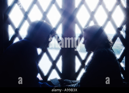 SILHOUETTE EINES PAARES VOR FENSTER Stockfoto