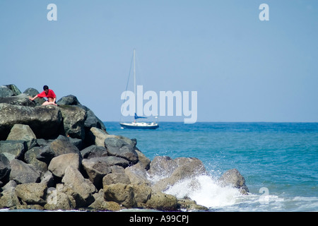 Felsiger Strand in Bray Head mit Segelboot Stockfoto