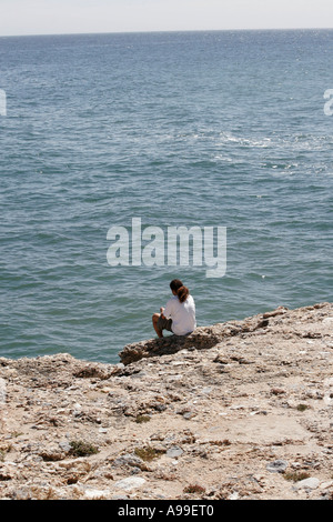 EINE EINSAME MÄNNLICHE FIGUR, BLICK AUF DAS MEER. Stockfoto