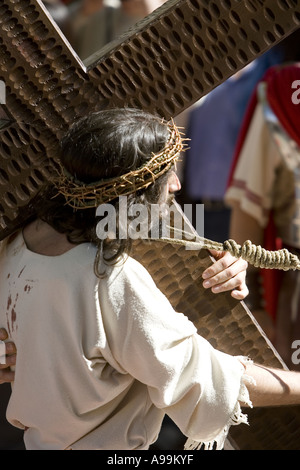 Schauspieler spielt Jesus Christus trägt ein hölzernes Kreuz während der Karwoche Passionsspiel, Balmaseda, Nordspanien. Stockfoto