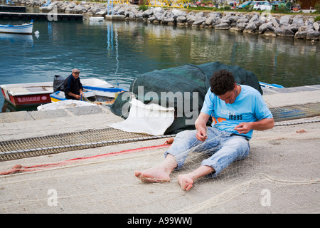 Sizilianische Fischer Flicken Fischernetze in der Marina auf der Mar Tirreno Cefalu-Sizilien-Italien Stockfoto