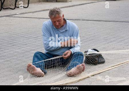 Sizilianische Fischer Netze reparieren Stockfoto