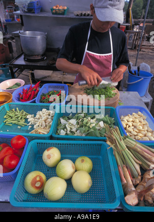 MALAYSIA Kedah Langkawi Kuah Hausierer Stände Koch bereitet thailändisches Gericht Tom Yam Suppe mit Zutaten, die vor ihm angeordnet. Stockfoto