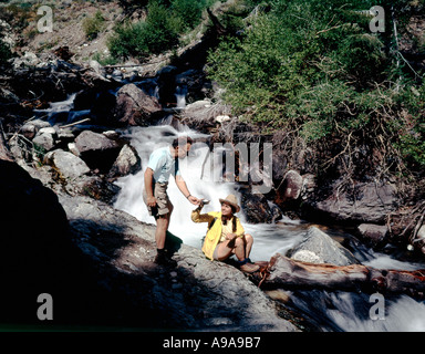 Wanderer zu stoppen für ein kühles Getränk aus dem rauschenden Boulder Creek in den Pioneer-Bergen von Zentral-Idaho Stockfoto