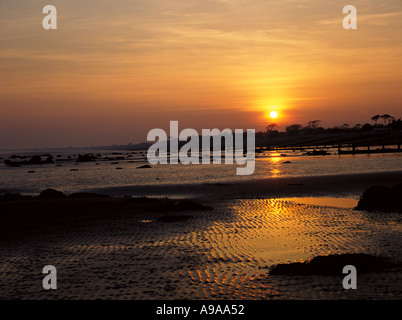 Tiefstehende Sonne spiegelt sich im nassen Sand am Strand von WEST SUSSEX England UK Stockfoto