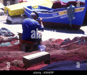 1999 HISTORISCHE, ÄLTERE FISCHER, DIE BEIM AUSBESSERN VON NETZEN SITZEN ALBUFEIRA ALGARVE PORTUGAL Stockfoto