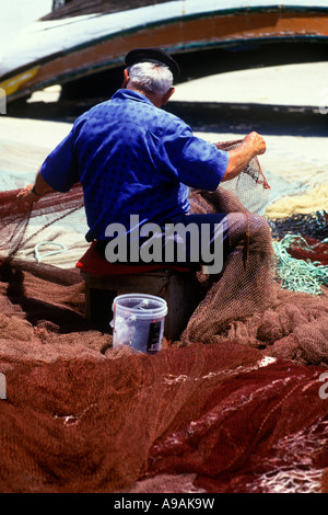 1999 HISTORISCHE, ÄLTERE FISCHER, DIE BEIM AUSBESSERN VON NETZEN SITZEN ALBUFEIRA ALGARVE PORTUGAL Stockfoto