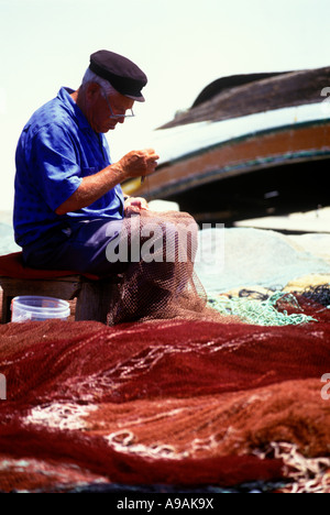 1999 HISTORISCHE, ÄLTERE FISCHER, DIE BEIM AUSBESSERN VON NETZEN SITZEN ALBUFEIRA ALGARVE PORTUGAL Stockfoto