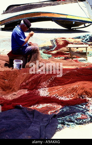 1999 HISTORISCHE, ÄLTERE FISCHER, DIE BEIM AUSBESSERN VON NETZEN SITZEN ALBUFEIRA ALGARVE PORTUGAL Stockfoto