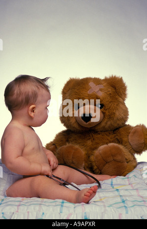 SÄUGLING BABY SPIELEN ARZT MIT STOFFTIER TEDDYBÄR Stockfoto