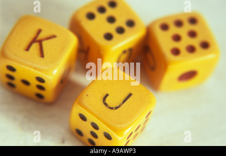Nahaufnahme von vier gelbe Elfenbein Poker Würfel auf einem cremefarbenen Stein oder Gips Oberfläche mit Jack King Seven und acht Gesicht Stockfoto