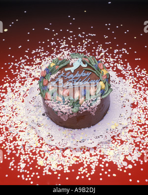 HAPPY BIRTHDAY PARTY KUCHEN AUF ROTEM GRUND Stockfoto