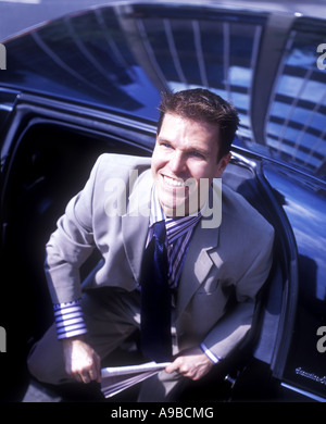 BÜROANGESTELLTER VERLASSEN LIMO BLICKTE LÄCHELND Stockfoto