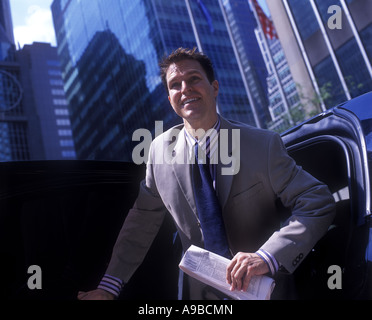 JUNGE LÄCHELNDE OFFICE WORKER VERLASSEN LUXUS LIMOUSINE MANHATTAN NEW YORK CITY USA Stockfoto