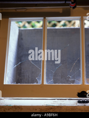 KAPUTTE FENSTERSCHEIBEN MIT RAHMEN EINES OFFENEN KELLERFENSTERS Stockfoto